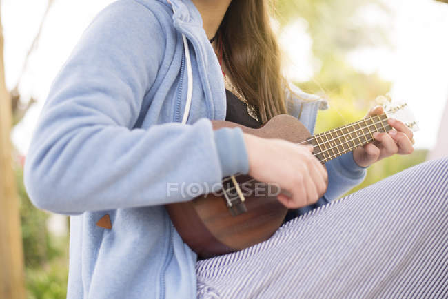 Mani femminili che giocano ukelele — Foto stock