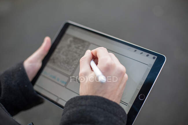 Крупним планом руки врожаю людини використовуючи планшет з ручкою — стокове фото