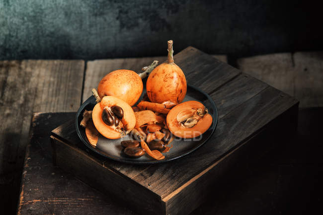Fresh whole and halved loquats — Stock Photo