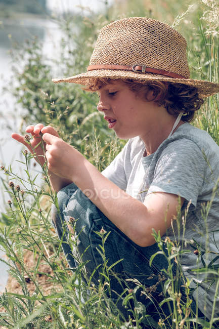 Мальчик, сидящий у реки — стоковое фото