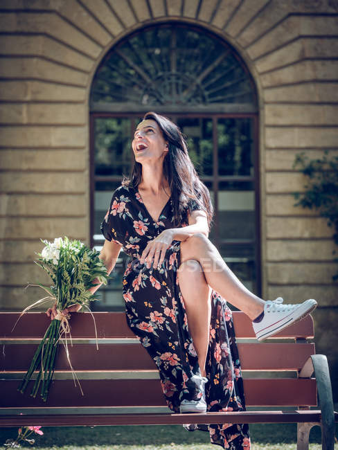 Donna con mazzo di fiori sulla panchina — Foto stock