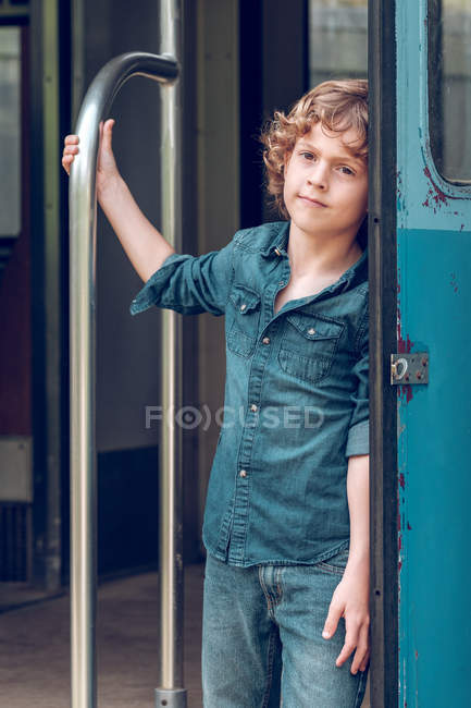 Niño de pie en vagón de tren - foto de stock