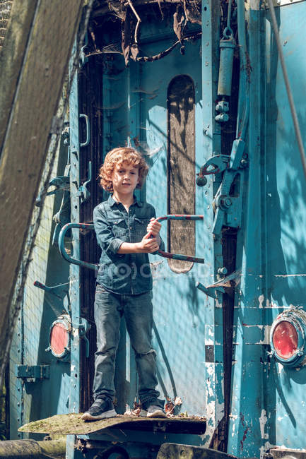 Niño de pie en vagón abandonado - foto de stock
