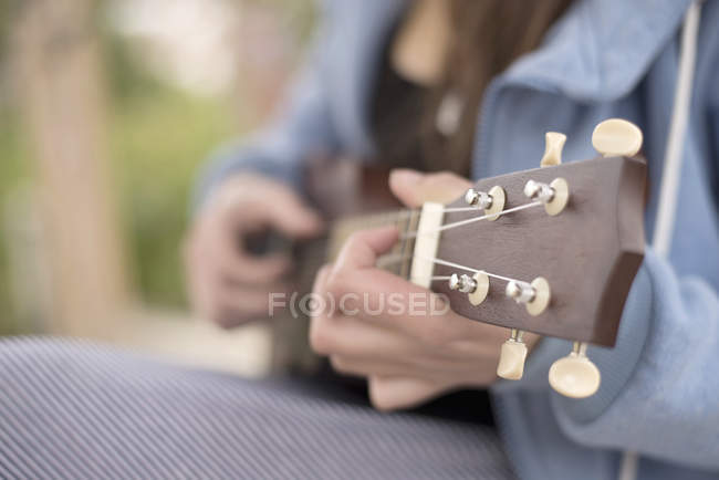 Female hands playing ukelele — Stock Photo