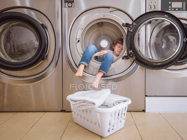 Menino dormindo na máquina de lavar roupa — Fotografia de Stock