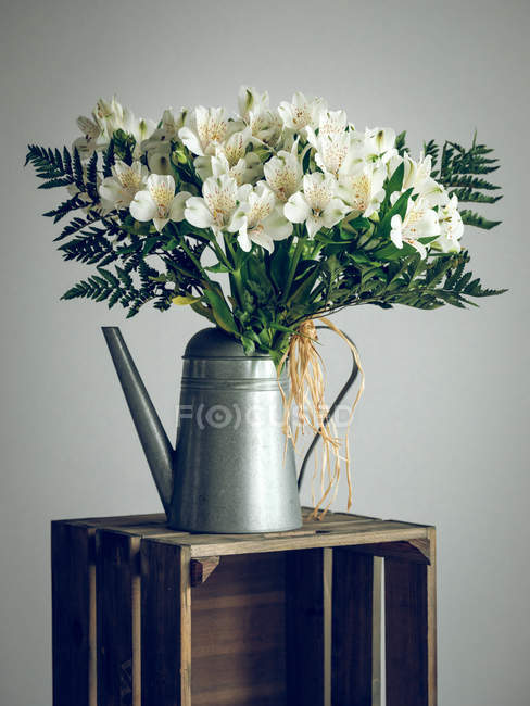 Bunch of flowers in watering can — Stock Photo
