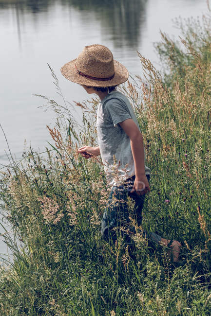 Мальчик, стоящий у реки — стоковое фото
