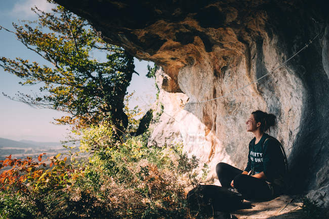 Donna seduta al muro roccioso — Foto stock