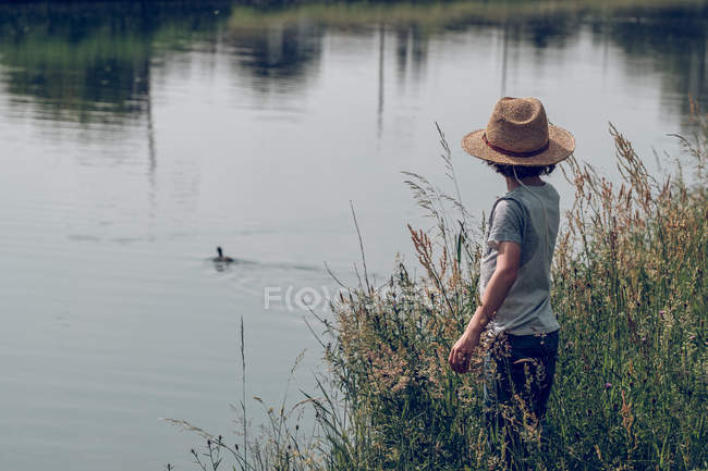 Petit garçon debout à la rivière — Photo de stock
