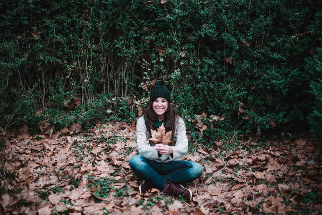 Жінка сидить на Осіннє листя — стокове фото