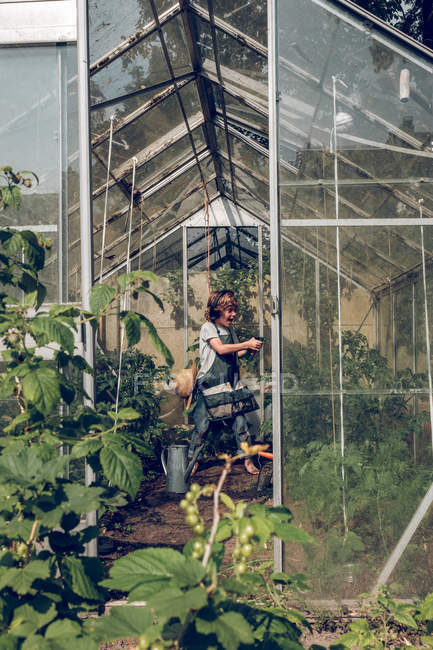 Kid listening to music in greenhouse — Stock Photo