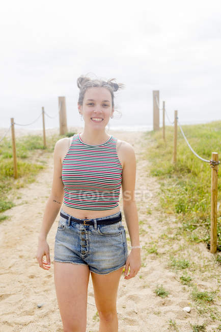 Woman standing on sandy path — Stock Photo