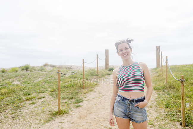 Mujer de pie en el camino arenoso - foto de stock