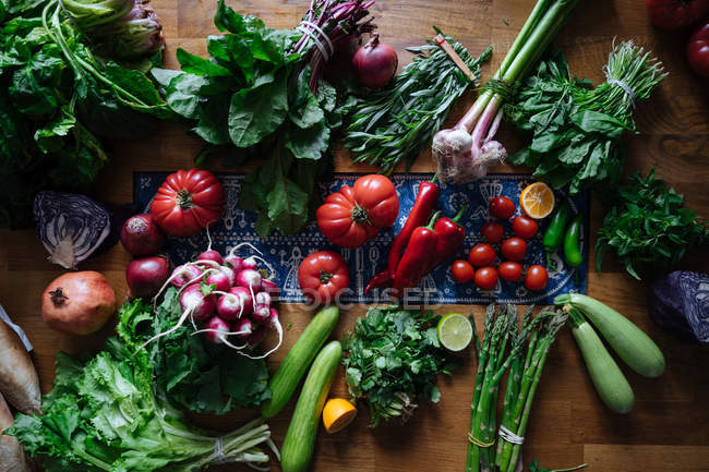 Свіжі овочі та зелень на дерев'яному столі — стокове фото