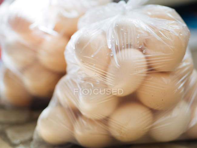 Sacchetti di plastica trasparente riempiti con uova fresche fattoria — Foto stock