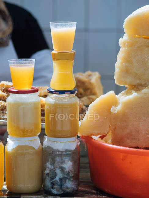 Frascos apilados de miel dorada orgánica en la mesa - foto de stock