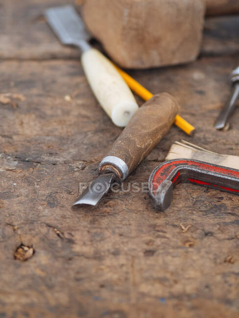 From above shot of shabby wooden table with set of craft tools for carving on wood, Uzbekistan — Stock Photo