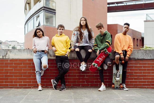 Adolescentes con patinetas en la valla - foto de stock