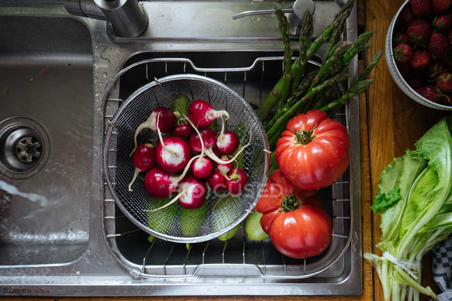 Fresh washed vegetables in kitchen sink — Stock Photo