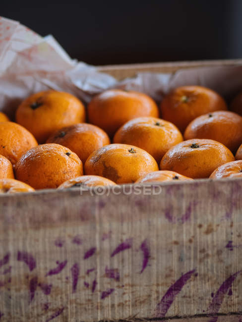 Primer plano de naranjas maduras en caja de madera - foto de stock