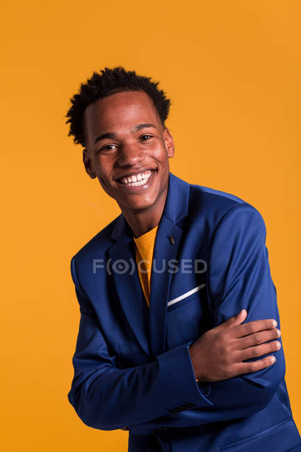Retrato de sorridente dandy preto homem em jaqueta no fundo laranja — Fotografia de Stock