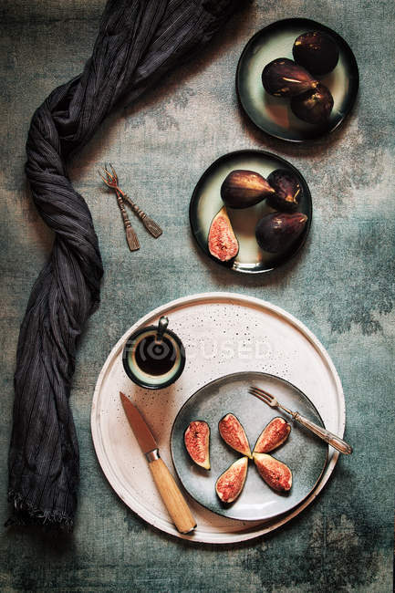Figues fraîches entières et tranchées servies dans des assiettes — Photo de stock