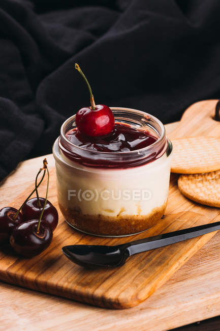 Postre dulce con mermelada en tarro sobre tabla de madera - foto de stock