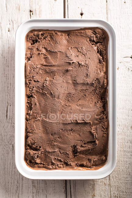 Homemade chocolate ice cream in box on wooden surface — Stock Photo