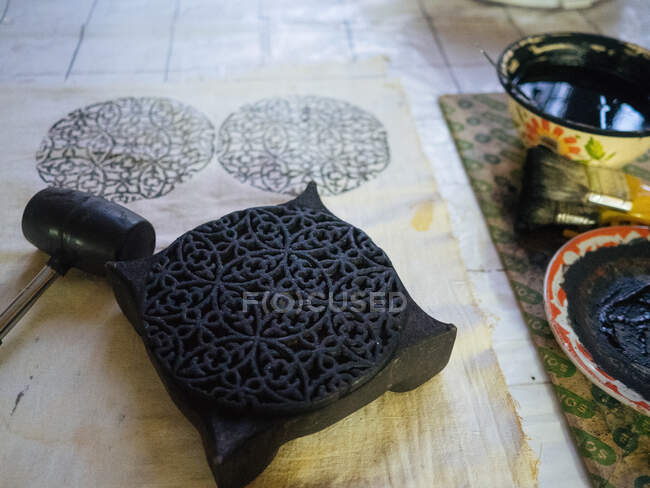 Pochoir, marteau et pinceaux traditionnels ouzbeks authentiques avec peinture noire dans des bols — Photo de stock