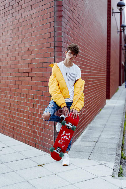Adolescente com skate na esquina — Fotografia de Stock