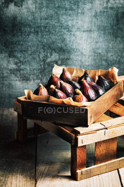 Fichi freschi in scatola di legno su sfondo grigio squallido — Foto stock