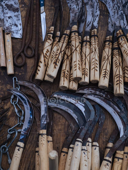 De arriba plano de herramientas gruesas e instrumentos para trabajos agrícolas dispuestos sobre mesa de madera - foto de stock