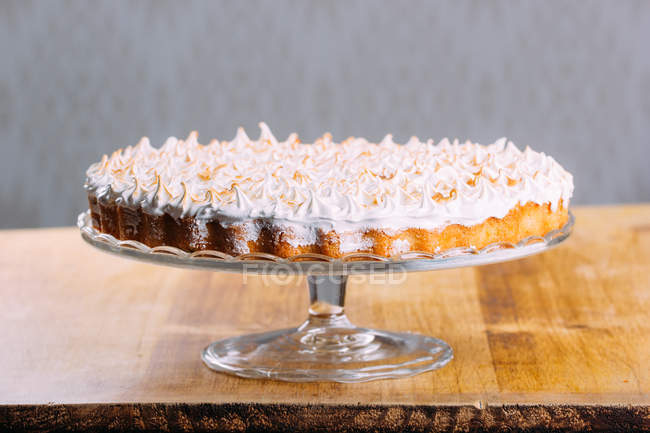 Crispy tart topped with baked white fluffy meringue on cake stand — Stock Photo