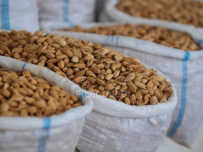 Fabric bags filled with dried almonds at farmer market — Stock Photo