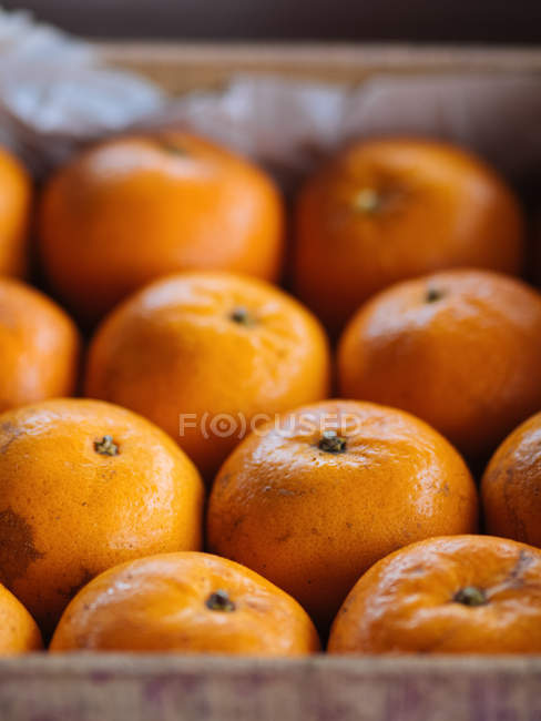 Close-up of ripe oranges in wooden box — Stock Photo