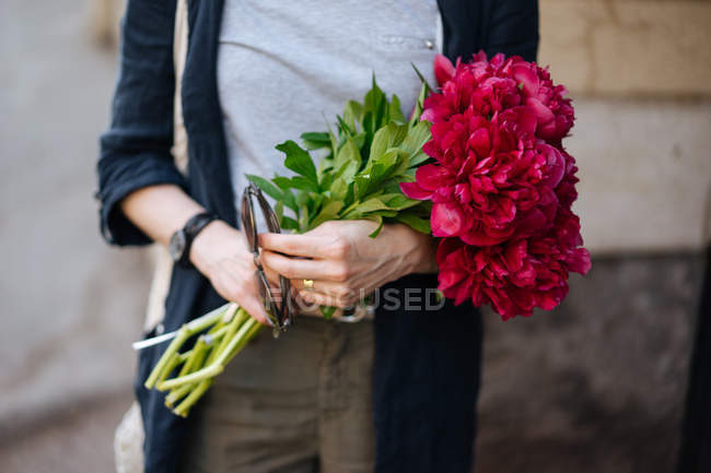 Gros plan de la femme tenant un bouquet de pivoines roses — Photo de stock
