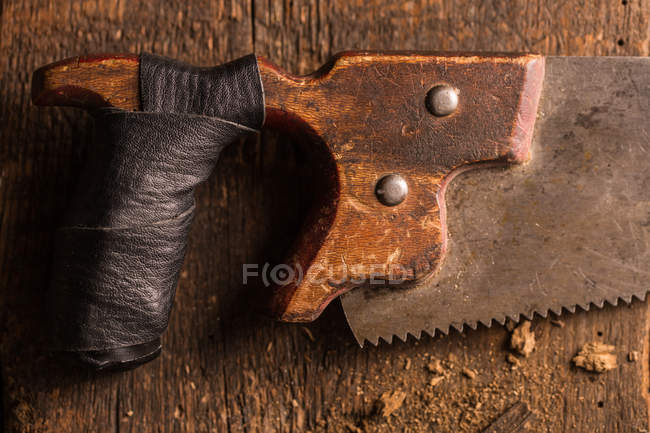Close-up de serra de mão enferrujada na superfície de madeira — Fotografia de Stock