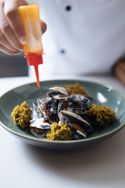 Chef dripping with sauce Nordic seafood dish with mussels on plate — Stock Photo