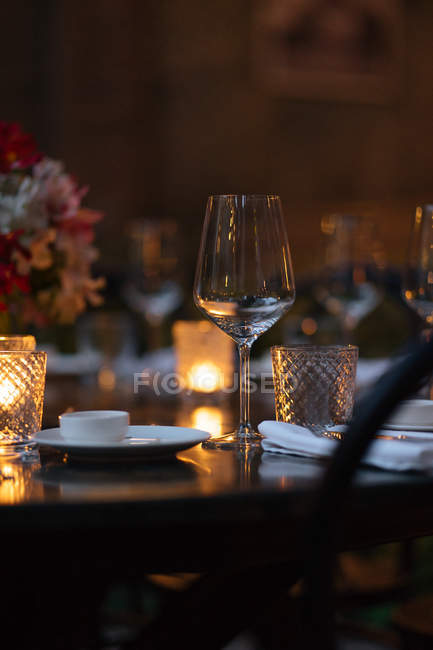 Close-up de mesa de ajuste decorado com velas e flores à noite — Fotografia de Stock