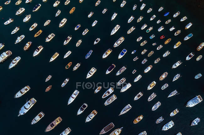 Picturesque aerial view of colorful small boats and yachts sailing on event surrounded by deep dark water — Stock Photo