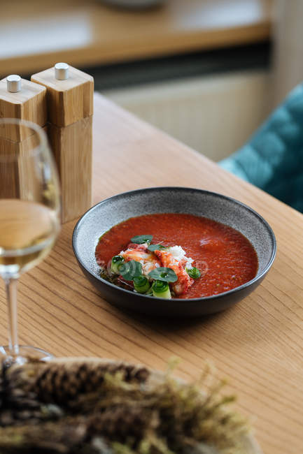 Tradizionale zuppa rossa nordica guarnita con erbe aromatiche in ciotola sul tavolo di legno — Foto stock