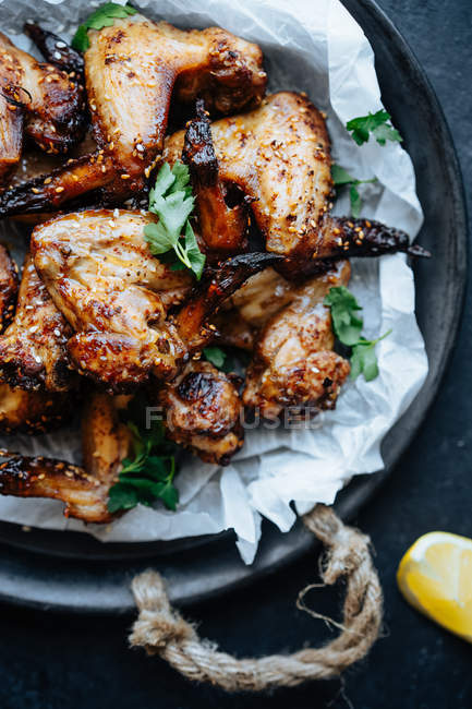 Close-up de assadeira de asas de frango assadas em gergelim e salsa — Fotografia de Stock