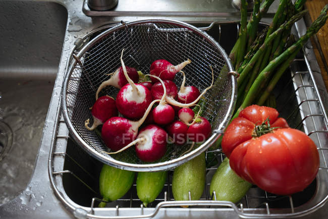 Fresh washed vegetables in kitchen sink — Stock Photo
