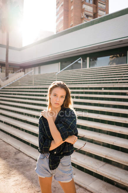 Приваблива молода жінка стоїть перед сходами на вулиці — стокове фото