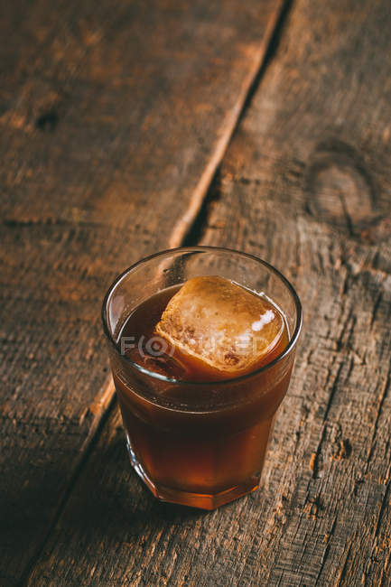 Café froid glacé en verre sur une surface en bois — Photo de stock