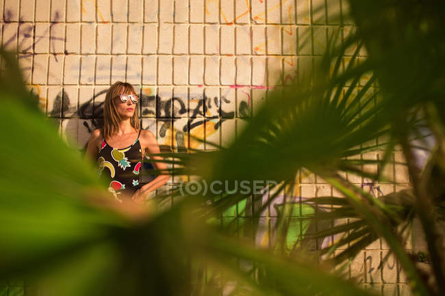 Stylish modern woman in urban background with frond — Stock Photo