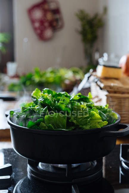 Foglie di spinaci in vaso sul fornello a gas — Foto stock