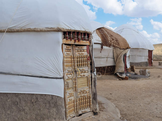 Exterior de tendas nômades tradicionais yurtas em terra seca de terreno, Uzbequistão — Fotografia de Stock