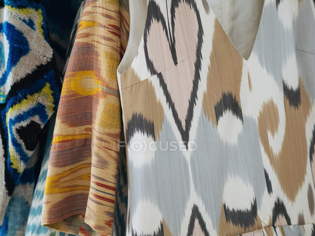 Красочные различные местные платья висят на деревянных вешалках — стоковое фото