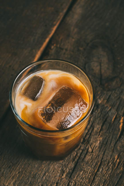 Café froid glacé en verre sur une surface en bois — Photo de stock